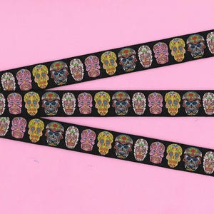May include: Black ribbon with a repeating pattern of colorful sugar skulls. The skulls are decorated with flowers and other details.