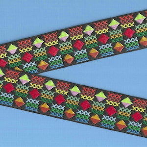 May include: Black ribbon trim with a colorful geometric pattern of diamonds and squares in shades of red, orange, yellow, green, blue, and pink.