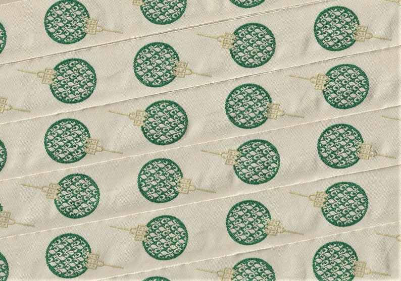 Puede incluir: Una cinta de tela blanca con un patr&oacute;n repetido de c&iacute;rculos verdes. Cada c&iacute;rculo tiene un dise&ntilde;o detallado de un patr&oacute;n floral estilizado.