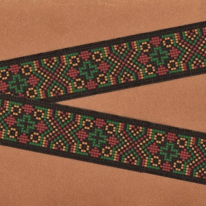 May include: Black and brown woven ribbon with a geometric pattern in red, green, and yellow.
