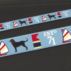 May include: Blue and white ribbon with a repeating pattern of a black dog, a sailboat, and the text "ESTD 71".