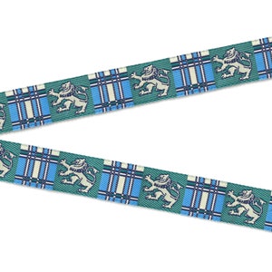 May include: A green, blue, and white ribbon with a repeating pattern of a lion and a plaid design.