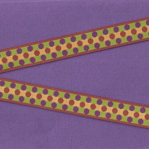 May include: Two strips of ribbon with a polka dot pattern in shades of green, purple, brown, and gold on a purple background.