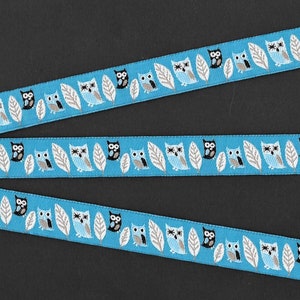 ANIMAIS/Pássaros C-08-A Fita Jacquard de Poliéster com Acabamento de 5/8" de Largura (16 mm) Fundo Azul-Céu com Corujas Pretas e Azuis, Penas Brancas