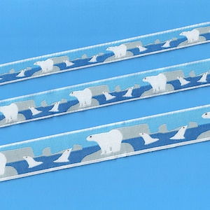 Puede incluir: Osos polares blancos caminando sobre témpanos de hielo con agua azul y rocas grises en el fondo. El diseño se repite en una cinta blanca.