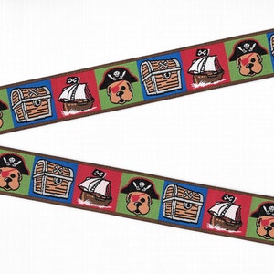 May include: A decorative ribbon featuring a repeating pattern of cartoon pirate dogs wearing eye patches, wooden treasure chests, and sailing ships. The design is set against alternating red, green, and blue square backgrounds with brown borders.