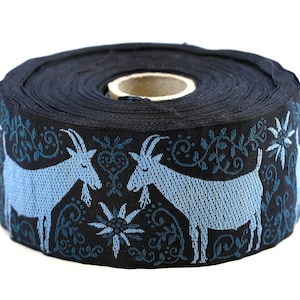 May include: A roll of black ribbon featuring a repeating pattern of light blue goats and floral designs. The ribbon is tightly wound, showcasing the decorative edge with detailed animal and plant motifs.