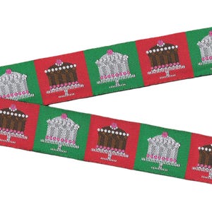 May include: A woven fabric ribbon featuring a repeating pattern of cakes on stands. The design alternates between red and green square blocks. Each cake is depicted in brown or white with pink accents, arranged in a continuous horizontal line.