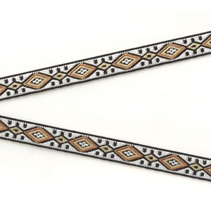 May include: A black and white trim with a geometric pattern in shades of brown and gold.