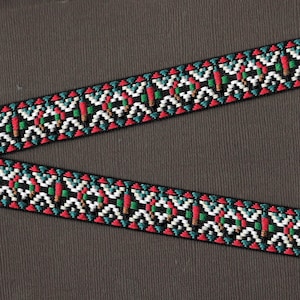 May include: Black and white trim with red, green, and blue geometric patterns. The trim is woven with a repeating pattern of triangles and zigzags.