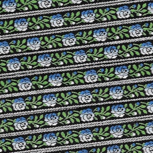 May include: Black fabric with a repeating pattern of white and blue roses with green leaves. The fabric has a woven texture.