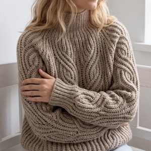 May include: A beige long-sleeve sweater featuring a mock neck collar and a prominent cable knit pattern. The garment is constructed with a thick, textured yarn, showcasing vertical cable designs on the chest and sleeves with ribbed cuffs.