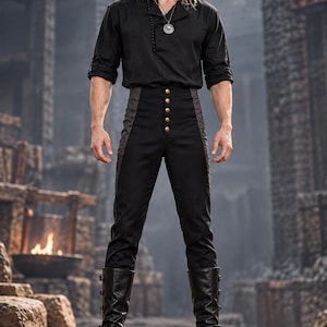 May include: A black long-sleeved shirt with a V-neckline, paired with high-waisted black trousers featuring a vertical row of five gold-toned buttons at the center. The outfit includes black leather knee-high boots with side buckles and a silver pendant.