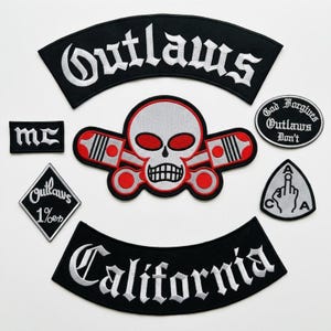 Puede incluir: Un conjunto de parches bordados que incluye un rocker negro grande con texto blanco Outlaws, un emblema central de calavera y pistones en rojo, blanco y negro, un rocker California, un parche en forma de diamante 1%er, un parche MC y dos parches circulares pequeños.