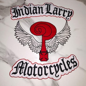 May include: A fabric patch featuring the text Indian Larry in black gothic lettering at the top and Motorcycles in black gothic lettering at the bottom. In the center is a red question mark symbol with white wings and a red cross base.