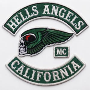 May include: A set of embroidered patches featuring a green and white arched top rocker with the text HELLS ANGELS, a matching bottom rocker with CALIFORNIA, a central winged skull emblem in green, black, and red, and a small rectangular MC patch.