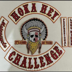 May include: A set of embroidered patches featuring a central skull wearing a feathered headdress and a patterned bandana. The text HOKA HEY and CHALLENGE are in large red letters on white curved patches. Two vertical strips read PROFESSIONAL and LONG RIDER.
