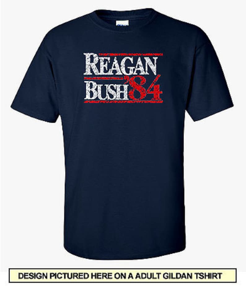 May include: A navy blue t-shirt with a white and red distressed graphic that reads "Reagan Bush '84".