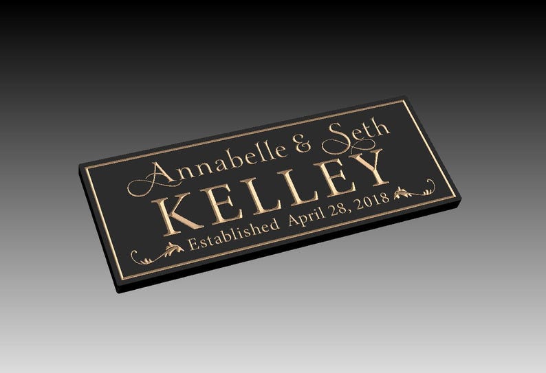 Puede incluir: Placa rectangular negra con letras doradas. La placa dice "Annabelle & Seth Kelley" encima de "KELLEY" y "Established April 28, 2018". Hay adornos decorativos en la placa.