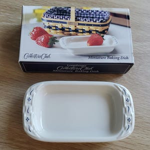 May include: A rectangular white ceramic miniature baking dish with blue floral accents on the short ends. The dish is presented with its original box, which features the text Collectors Club Miniature Baking Dish and an image of a woven basket.