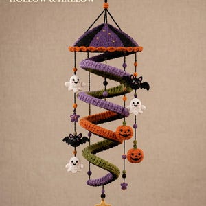 May include: A hanging crochet mobile featuring a spiral structure in purple, orange, and green. It includes small crocheted figures of white ghosts, black bats, and orange jack-o'-lanterns, with a yellow star at the bottom. Text reads: DIGITAL CROCHET PATTERN HOLLOW & HALLOW.