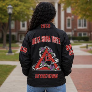 May include: A black windbreaker jacket featuring red and white embroidery on the back. The text reads Delta Sigma Theta, 1913, 13, and Devastating. A red triangle is outlined with white pearls and decorated with purple flowers and green leaves.