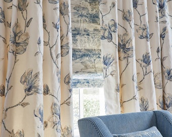 May include: A pair of white curtains with a blue floral pattern hang in a window. The curtains are drawn back to reveal a blue and white striped armchair with a pillow featuring a tree pattern.