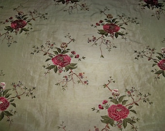 Può includere: Un tessuto beige con un motivo ripetitivo di rose rosa e foglie verdi ricamate.