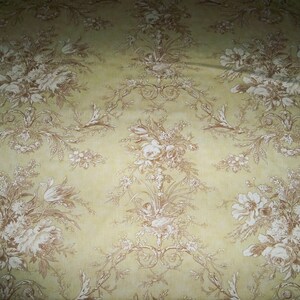 Puede incluir: Una tela beige con un patr&oacute;n floral blanco. El patr&oacute;n presenta un dise&ntilde;o repetitivo de flores y hojas estilizadas.