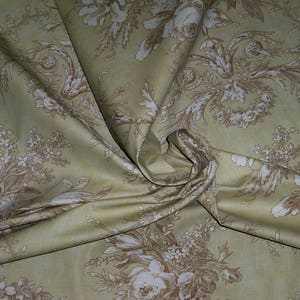 Puede incluir: Una tela beige con un patr&oacute;n floral marr&oacute;n. La tela est&aacute; doblada y drapeada, mostrando el patr&oacute;n en detalle.