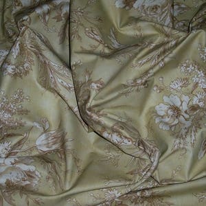 Puede incluir: Una tela beige con un patr&oacute;n floral en tonos marrones. La tela tiene una textura suave y arrugada y un brillo sutil.