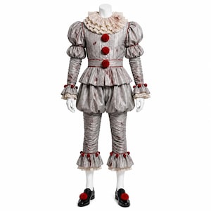 Puede incluir: Un disfraz de payaso gris con cuello de volantes, mangas abullonadas y pantalones fruncidos. La prenda está decorada con pompones rojos en el corpiño, los puños y los zapatos negros. La tela tiene un patrón de rayas finas y manchas rojas.