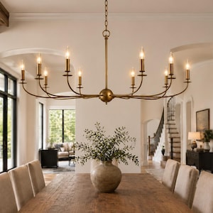 May include: A large, multi-armed brass chandelier with ten vertical candle-style light fixtures, suspended by a central chain. The fixture features curved arms extending from a central sphere, finished in a warm, metallic brass tone.