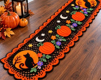 May include: A rectangular crochet table runner featuring a black mesh base with a scalloped orange border. The design includes appliqués of orange pumpkins, purple flowers, green leaves, white crescent moons, stars, and black cats against orange moons.
