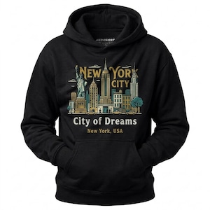May include: A black hooded sweatshirt featuring a graphic of the New York City skyline, including the Statue of Liberty and skyscrapers. The text reads NEW YORK CITY, City of Dreams, and New York, USA in gold and white lettering on the front.