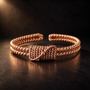 May include: A copper-colored cuff bracelet featuring a double-strand twisted wire design. The center of the bracelet is adorned with a rectangular section of tightly wrapped, horizontal twisted wire, finished with a small, smooth metal bead.