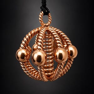 May include: A rose gold pendant featuring a central coiled spring surrounded by a spherical cage of twisted rope-textured metal bars, accented with smooth polished spheres at the intersections, suspended from a black cord.