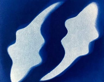 May include: A square tile featuring a deep blue background with two abstract, cloud-like shapes in a soft, glowing white. The shapes are positioned vertically, mirroring each other with irregular, wavy edges that create a sense of fluid motion.