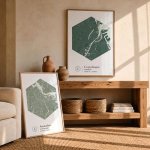 Peut inclure: Deux affiches encadrées présentant des cartes hexagonales de Copenhague et d'Amsterdam. L'impression de Copenhague affiche le nom de la ville, Danemark, et les coordonnées. Celle d'Amsterdam indique le nom de la ville, Pays-Bas, et les coordonnées.