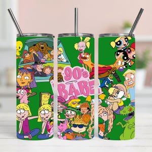 May include: A cylindrical metal tumbler with a green background featuring a collage of various 90s cartoon characters and the pink text 90's BABE. The tumbler includes a clear lid and a straight metal straw extending from the top center opening.