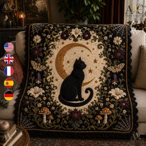 May include: A rectangular throw blanket featuring a central black cat sitting before a golden crescent moon and stars. The border is decorated with embroidered flowers, mushrooms, moths, and spiderwebs on a black background with a scalloped edge.