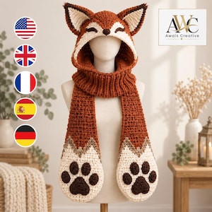 May include: A crochet fox-themed hooded scarf in rust orange, cream, and dark brown. The hood features pointed ears and a fox face, while the long scarf ends include cream-colored pockets with dark brown paw print designs. Text reads Awais Creative.