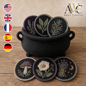 May include: A dark gray crocheted cauldron basket containing three circular coasters with embroidered botanical designs. Three additional circular coasters featuring embroidered mushroom, flower, and lavender motifs are placed in front of the basket.