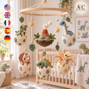 May include: A nursery mobile featuring crocheted dinosaurs in spotted eggs, including a T-Rex, a long-necked dinosaur, a triceratops, and a pterodactyl, centered around a crocheted volcano, all suspended from a circular wooden frame with stars and leaves.