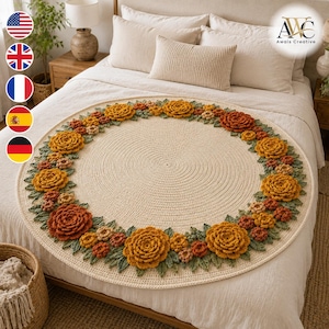 May include: A round, cream-colored crochet blanket featuring a decorative border of three-dimensional flowers in shades of orange, yellow, and rust, interspersed with green crocheted leaves. The center is a flat, circular, solid-stitch pattern.