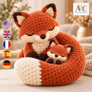 Könnte beinhalten: Ein gehäkeltes Fuchs-Stofftier, das einen großen erwachsenen Fuchs zeigt, der sich um ein kleineres Fuchsbaby rollt. Beide Füchse haben orangefarbene Körper, weiße Brust- und Schwanzspitzen sowie dunkelbraune Ohren und Pfoten. Text AWC Awais Creative.