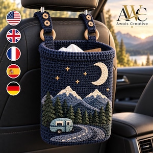May include: A dark blue crocheted car trash bag hanging from a headrest, featuring a night landscape with a crescent moon, stars, snow-capped mountains, a forest of pine trees, and a light blue camper trailer on a winding road.
