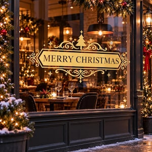 Pode incluir: Um adesivo dourado para janela com o texto MERRY CHRISTMAS em uma moldura decorativa com arabescos e um pequeno ícone de árvore. O design é aplicado em um vidro, com o interior de um restaurante e luzes de natal visíveis ao fundo.