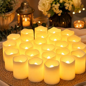 Op de afbeelding: Een set van vierentwintig cilindrische LED-kaarsen met een warm witte gloed en onregelmatige, gesmolten randen. Elke kaars op batterijen heeft een gladde, gebroken witte kunststof buitenkant en een kleine, heldere lichtbron in het midden.