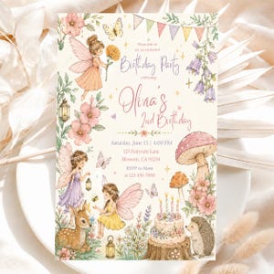 May include: A rectangular birthday party invitation card featuring watercolour illustrations of fairies, a fawn, a hedgehog, mushrooms, flowers, and a cake. The text reads: Please join us for an enchanted Birthday Party celebrating Olivia's 2nd Birthday.